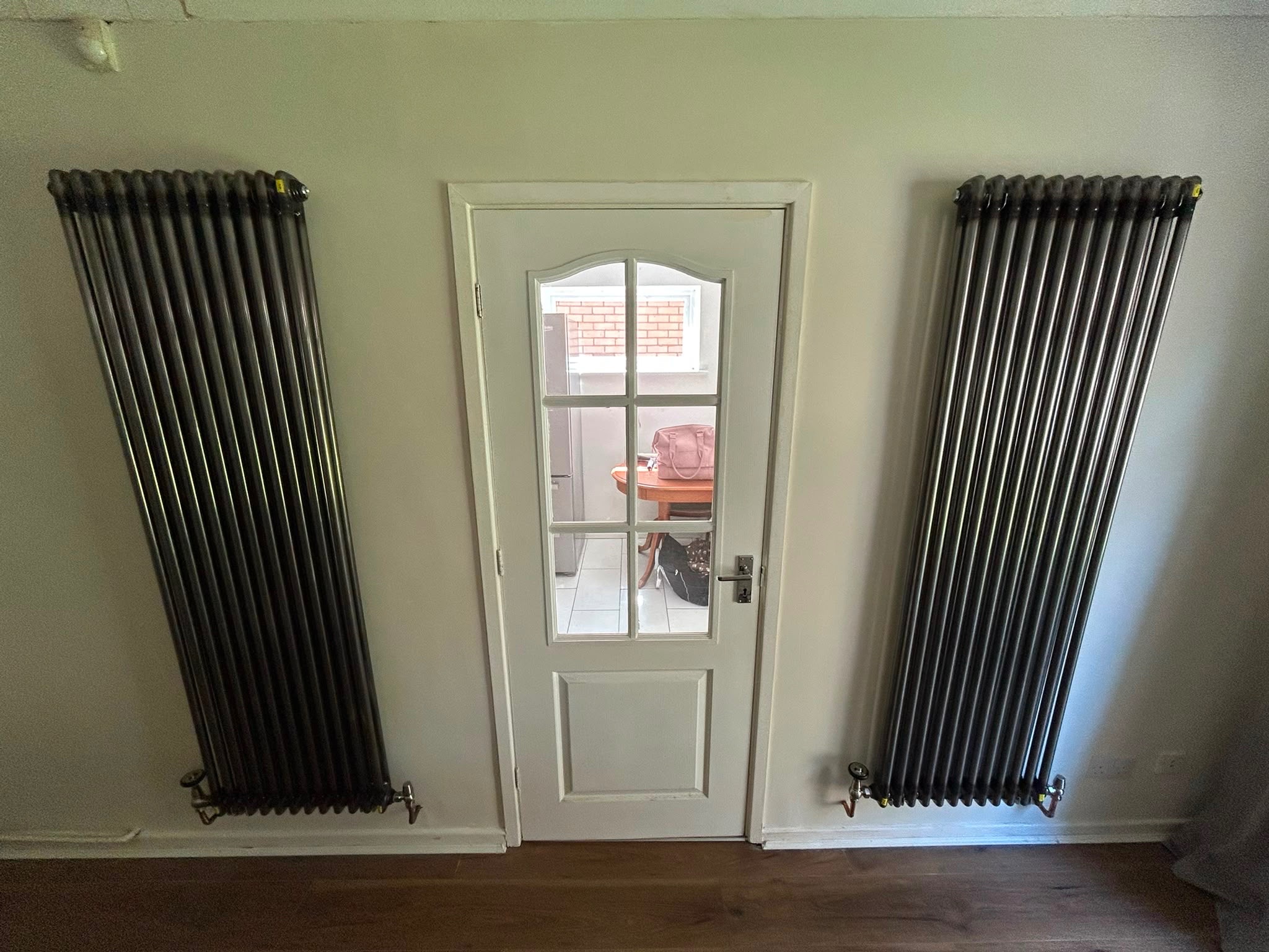 Two gunmetal grey designer column radiators fitted either side of a door in a Caerphilly home